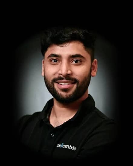 Glevin, co-founder of RainCity Property Maintenance, smiling in a black polo shirt against a dark studio backdrop.